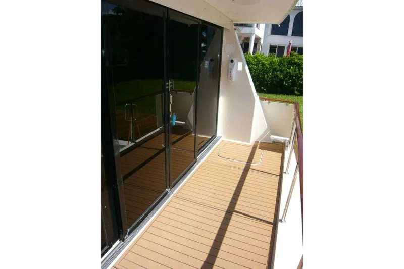 Slide: The Image of 1990 Viking Cockpit Motor Yacht deck with sliding glass doors and wooden flooring. - 18