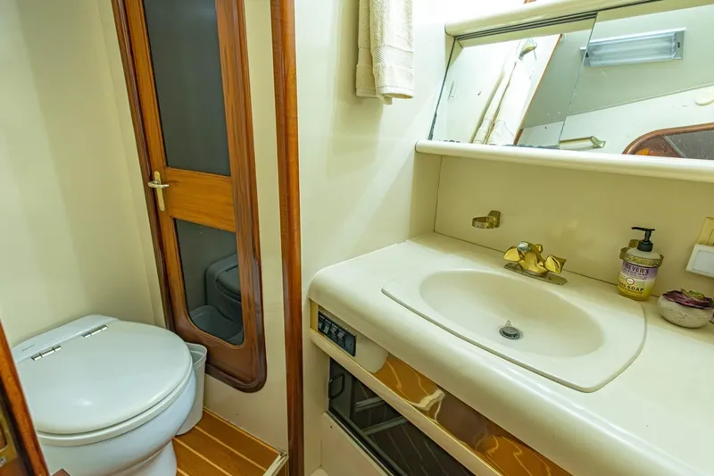 Slide: The Image of Bathroom interior of a 1990 Viking Cockpit Motor Yacht with sink and toilet. - 36