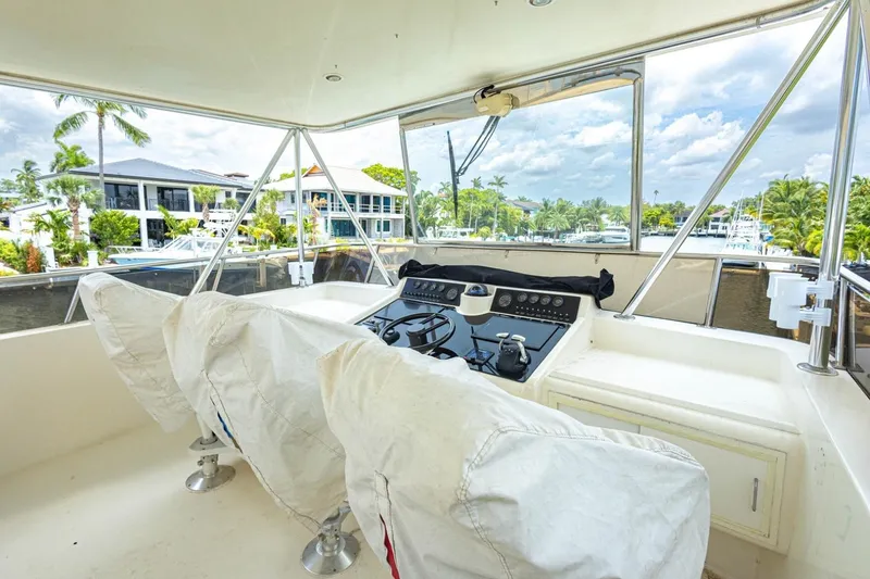 Slide: The Image of Cockpit view of a 1990 Viking Motor Yacht, featuring covered seats and a control panel. - 51
