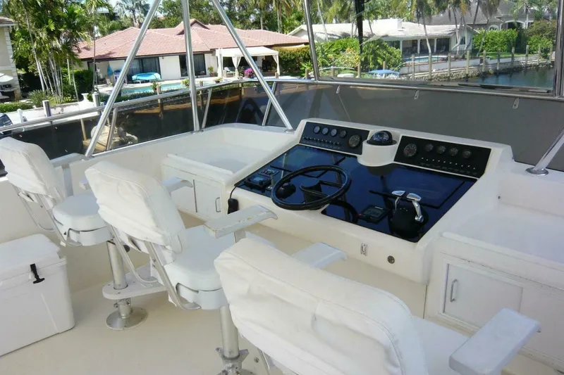 Slide: The Image of Cockpit of a 1990 Viking Motor Yacht with white seating and control panel. - 61