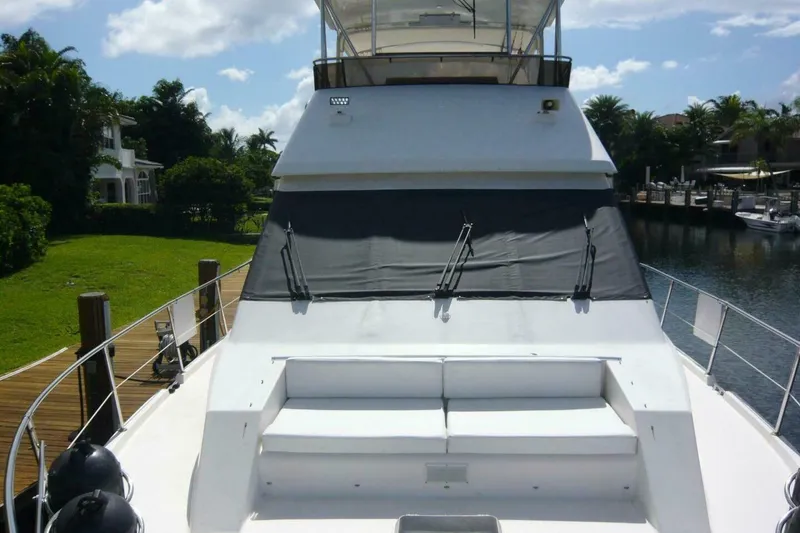 Slide: The Image of 1990 Viking Cockpit Motor Yacht docked by lush greenery and calm waters. - 69