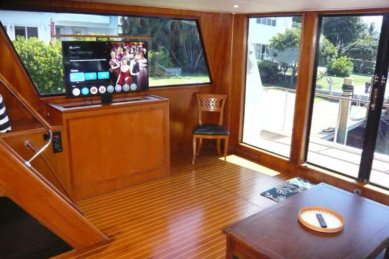 Slide: The Image of Interior of 1990 Viking Cockpit Motor Yacht with wood paneling and modern TV setup. - 8