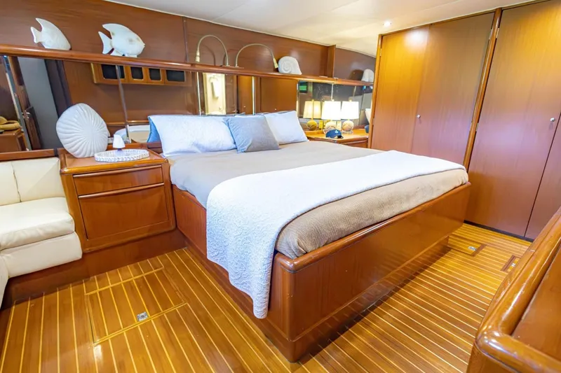 Slide: The Image of Luxurious 1990 Viking Cockpit Motor Yacht bedroom with elegant wood finishes and cozy bedding. - 27