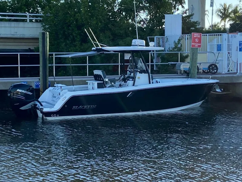 Slide: The Image of 2021 Blackfin 252 boat docked by a marina with Mercury outboard engine. - 2