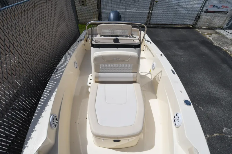 Slide: The Image of 2026 Scout 188 Sportfish boat with beige seating and sleek design in a fenced area. - 4