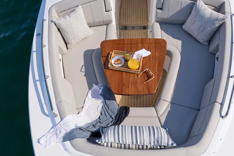 Slide: The Image of Luxurious seating area on 2026 MJM 38x boat with wooden table and cushions. - 12