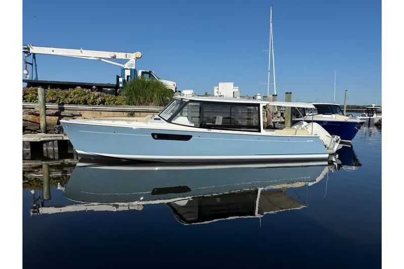 The Image of 2027 MJM 38 X boat docked in a serene marina, reflecting on calm water. - 0