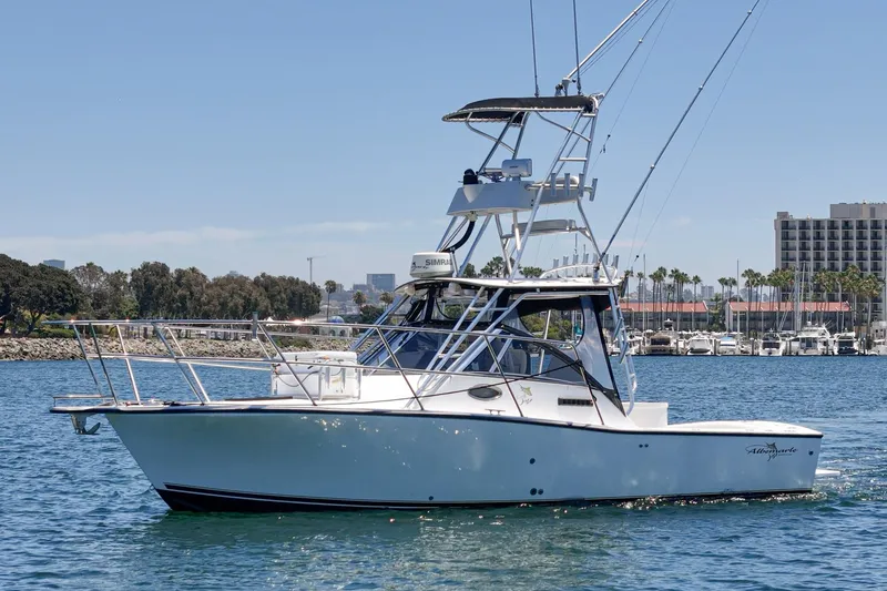Slide: The Image of 1999 Albemarle 290 Express Fisherman boat on water, with marina and buildings in background. - 1