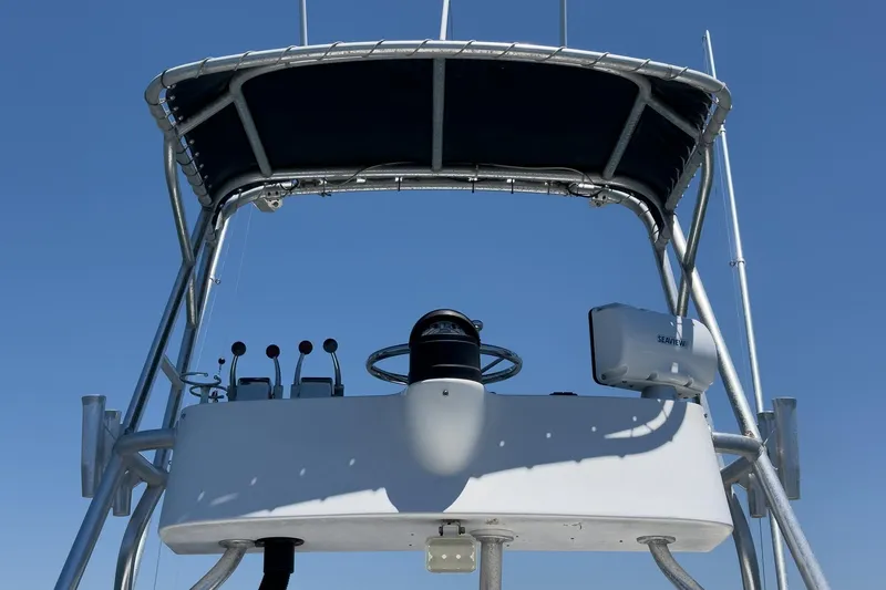 Slide: The Image of 1999 Albemarle 290 Express Fisherman helm with canopy against clear blue sky. - 13
