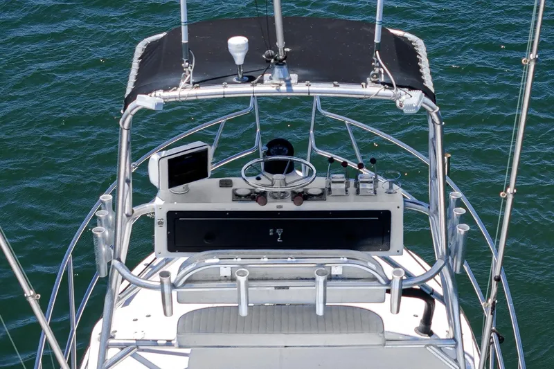 Slide: The Image of 1999 Albemarle 290 Express Fisherman helm with controls and canopy over water. - 14