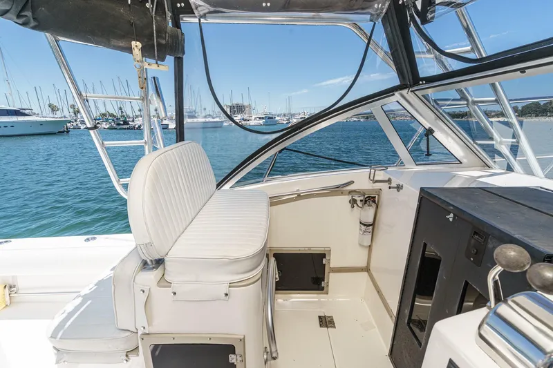 Slide: The Image of 1999 Albemarle 290 Express Fisherman boat interior with helm and seating, docked at marina. - 18