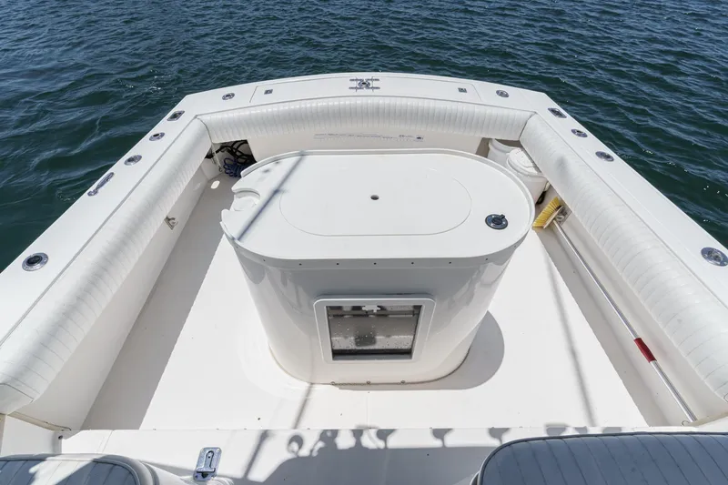 Slide: The Image of 1999 Albemarle 290 Express Fisherman boat deck with seating and storage, on calm water. - 25