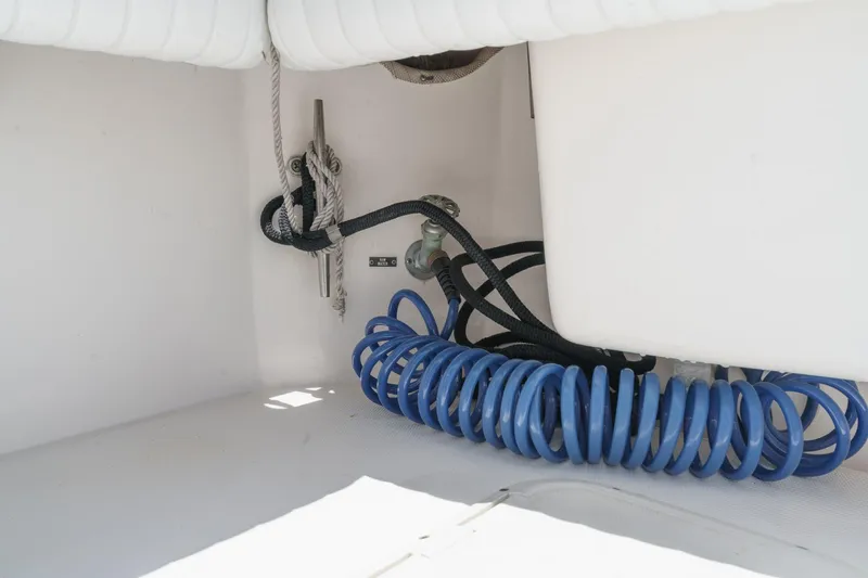 Slide: The Image of 1999 Albemarle 290 Express Fisherman boat interior with coiled blue hose and ropes. - 28