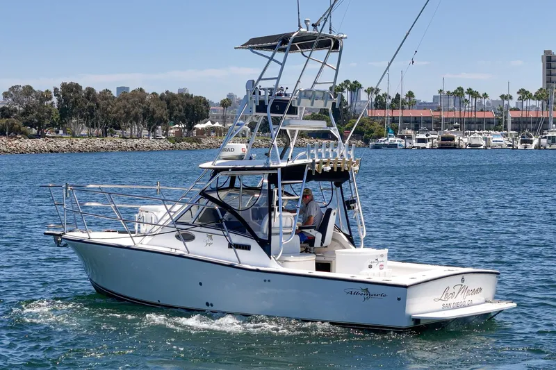 Slide: The Image of 1999 Albemarle 290 Express Fisherman boat cruising in a marina with clear blue water. - 3