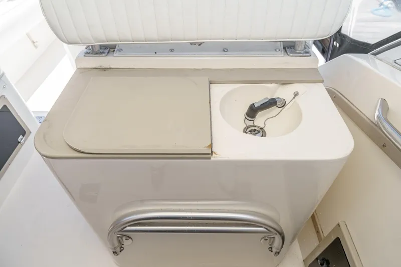 Slide: The Image of 1999 Albemarle 290 Express Fisherman boat sink and storage area. - 32