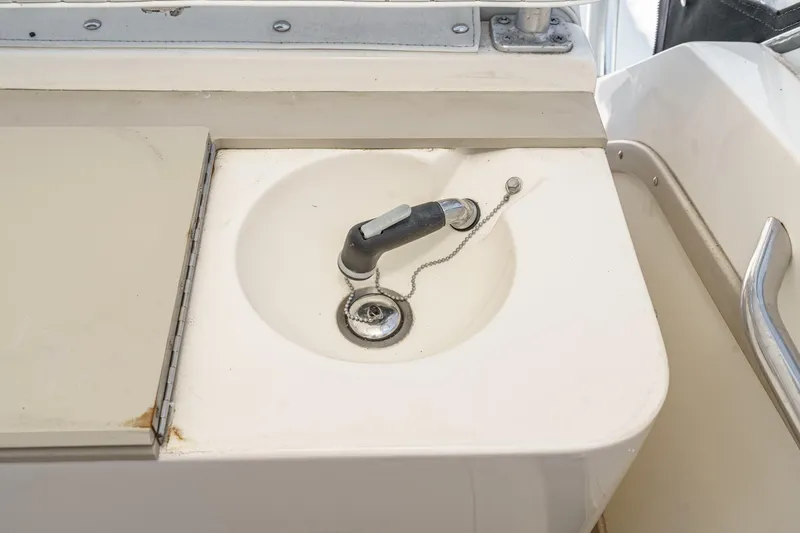 Slide: The Image of 1999 Albemarle 290 Express Fisherman boat sink with faucet and drain plug. - 33