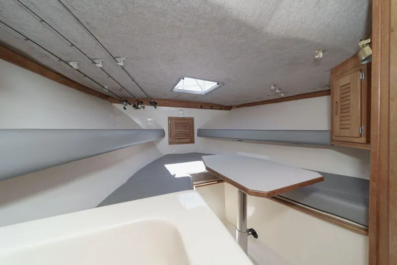 Slide: The Image of 1999 Albemarle 290 Express Fisherman cabin interior with table, storage, and overhead rods. - 50