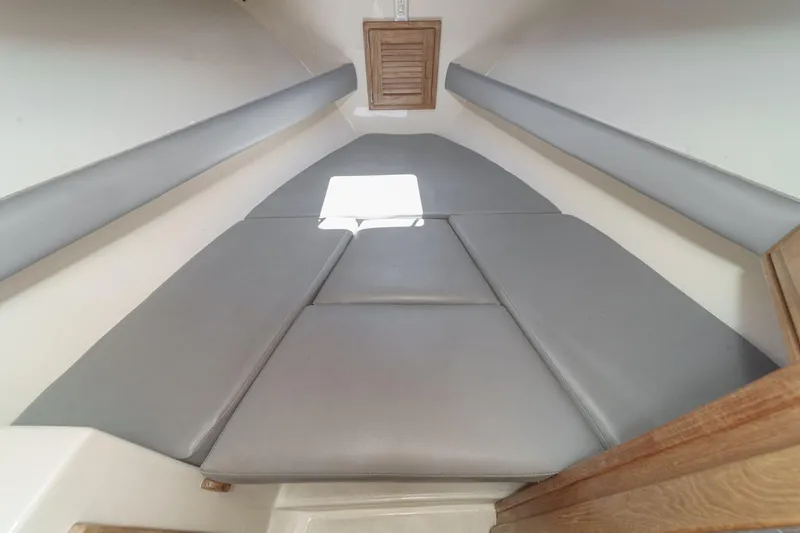 Slide: The Image of 1999 Albemarle 290 Express Fisherman cabin interior with gray cushions and wooden accents. - 51