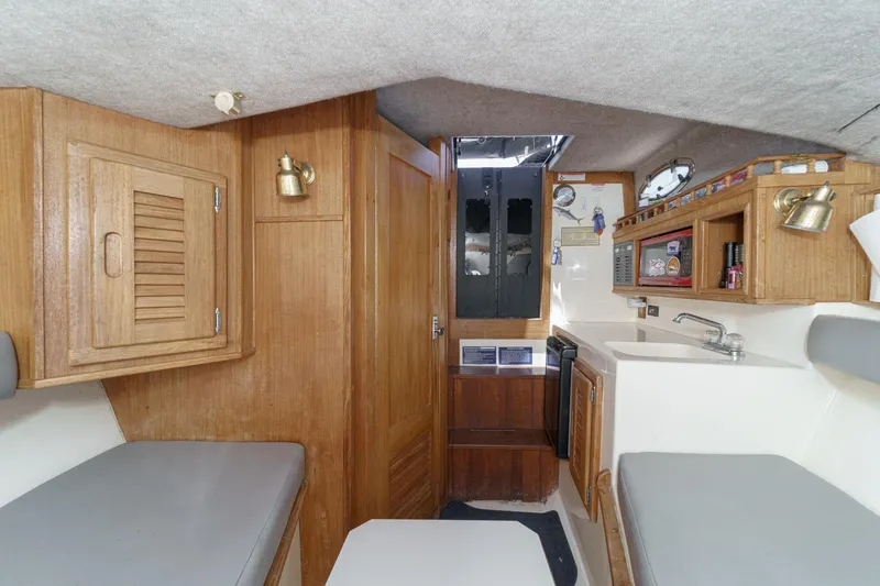 Slide: The Image of Interior of 1999 Albemarle 290 Express Fisherman boat with wood cabinetry and compact kitchen area. - 53