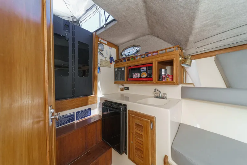Slide: The Image of Interior of 1999 Albemarle 290 Express Fisherman boat with kitchenette and seating area. - 54