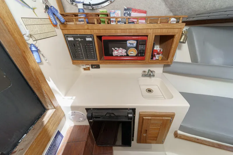 Slide: The Image of 1999 Albemarle 290 Express Fisherman cabin with sink, microwave, and storage. - 55