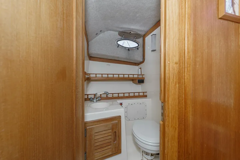Slide: The Image of 1999 Albemarle 290 Express Fisherman boat bathroom with wooden cabinetry and compact design. - 56