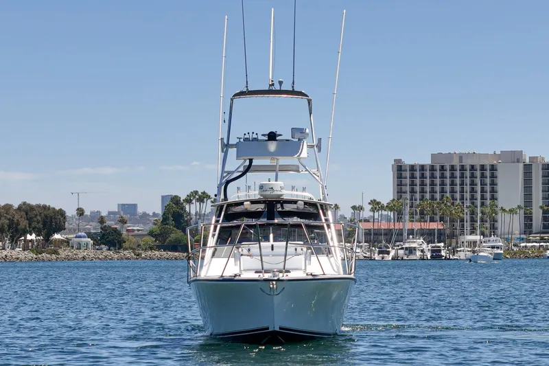 Slide: The Image of 1999 Albemarle 290 Express Fisherman boat on water, cityscape background, clear sky. - 6