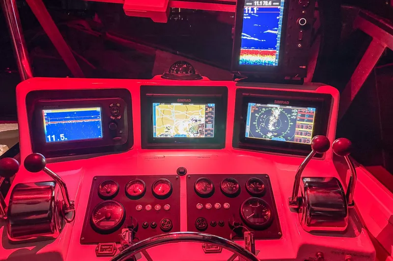 Slide: The Image of 1999 Albemarle 290 Express Fisherman dashboard with navigation and control systems illuminated in red. - 67