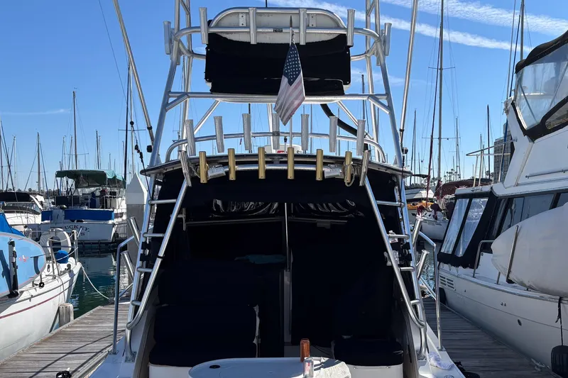 Slide: The Image of 1999 Albemarle 290 Express Fisherman docked at marina, featuring fishing rod holders and American flag. - 71