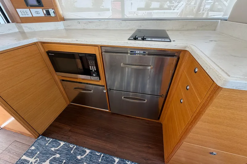 Slide: The Image of Modern kitchen in 2015 Riviera 445 SUV with microwave, stove, and stainless steel drawers. - 15