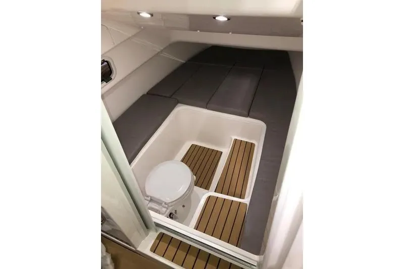 Slide: The Image of Interior cabin of 2020 Zar Formenti 85 SL boat with cushioned seating and compact toilet. - 13