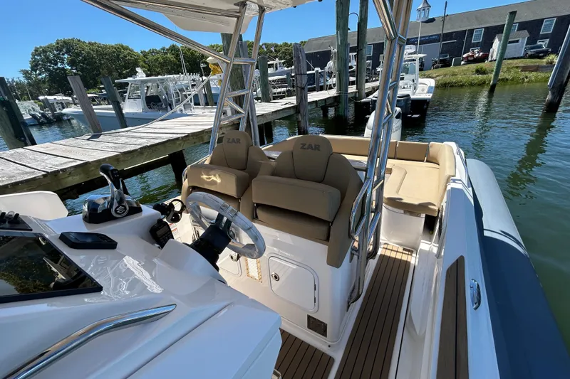 Slide: The Image of 2020 Zar Formenti 85 SL boat interior with helm, seats, and dock view. - 4