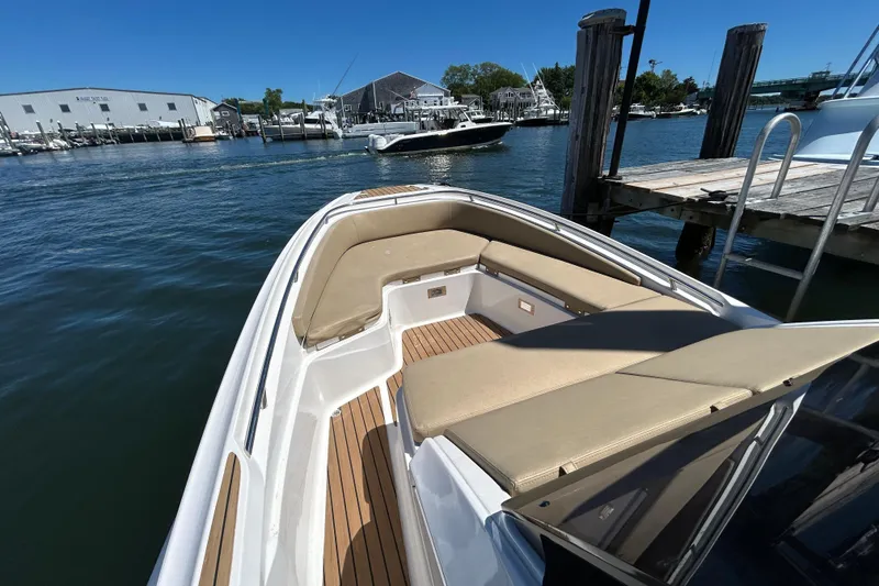 Slide: The Image of 2020 Zar Formenti 85 SL boat with beige seating, docked in a marina under clear blue skies. - 5