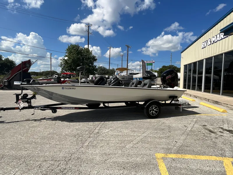 The Image of A 2023 Tracker boat on a trailer, parked in a lot near an RV dealership. - 1