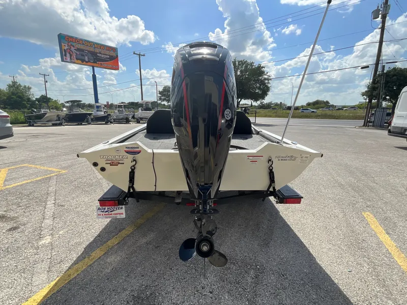 Slide: The Image of A 2023 Tracker boat with an outboard motor is parked in a lot under a cloudy sky. - 5