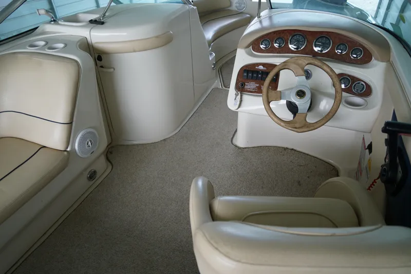 Slide: The Image of Interior of a 2000 Sea Ray 210 Sundeck boat with beige seating and dashboard. - 8