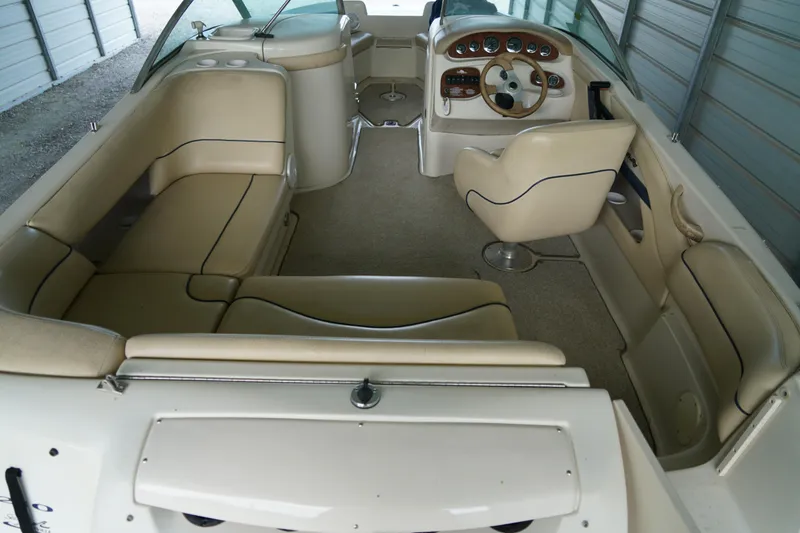 Slide: The Image of 2000 Sea Ray 210 Sundeck interior with beige seating and steering console. - 7