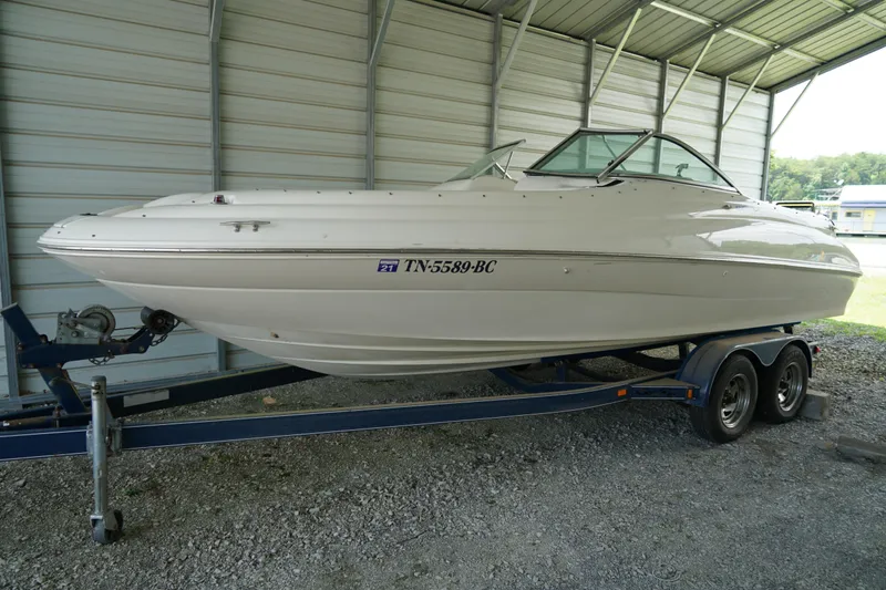 The Image of 2000 Sea Ray 210 Sundeck boat on trailer in covered storage area. - 0