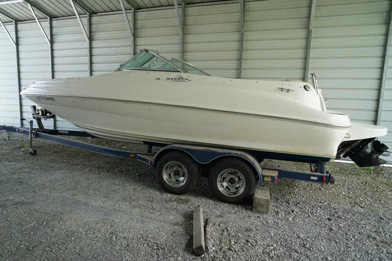 Slide: The Image of 2000 Sea Ray 210 Sundeck boat on trailer in covered storage area. - 3