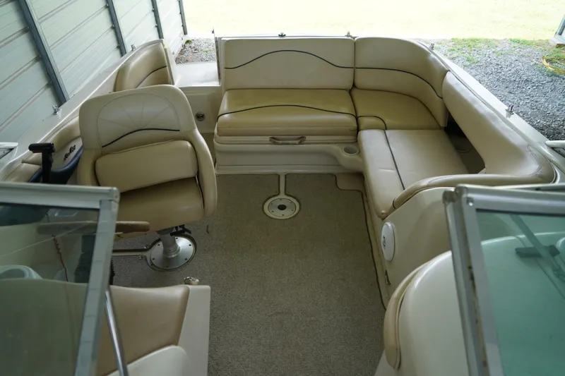 Slide: The Image of Interior of a 2000 Sea Ray 210 Sundeck with beige seating and carpeted floor. - 15