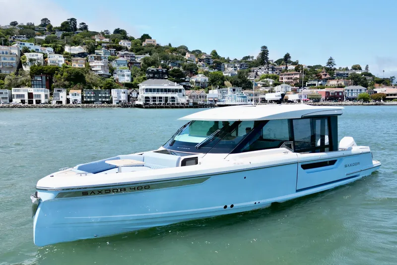Slide: The Image of Saxdor 400 GTC 2027 boat cruising near scenic coastal town. - 3