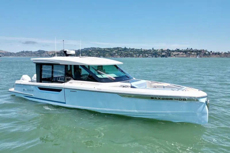 Slide: The Image of 2027 Saxdor 400 GTC luxury boat cruising on a sunny day in scenic waters. - 11