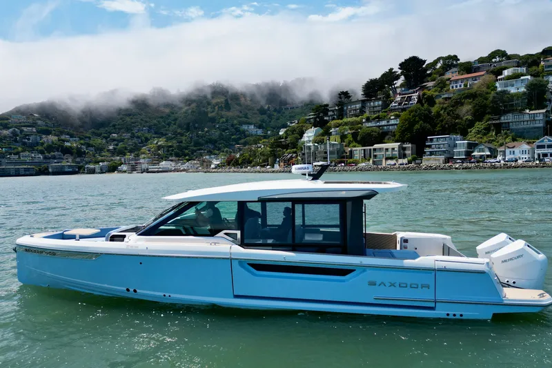 Slide: The Image of 2027 Saxdor 400 GTC boat cruising near scenic coastal hillside homes. - 5