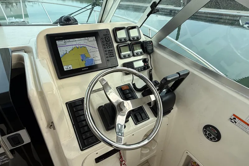 Slide: The Image of Helm of 2006 Pursuit 2570 Offshore boat with navigation equipment and steering wheel. - 12