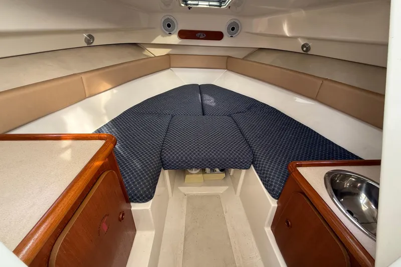Slide: The Image of Interior cabin of a 2006 Pursuit 2570 Offshore boat with cushioned seating and wood accents. - 13