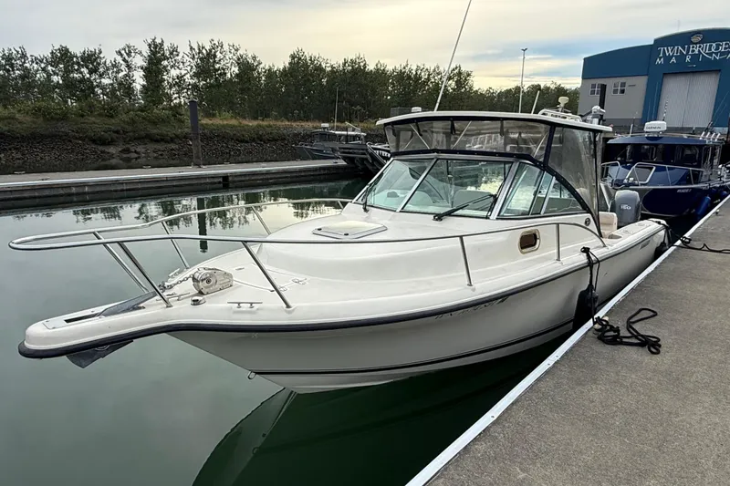 Slide: The Image of 2006 Pursuit 2570 Offshore boat docked at marina, featuring sleek design and spacious cabin. - 2