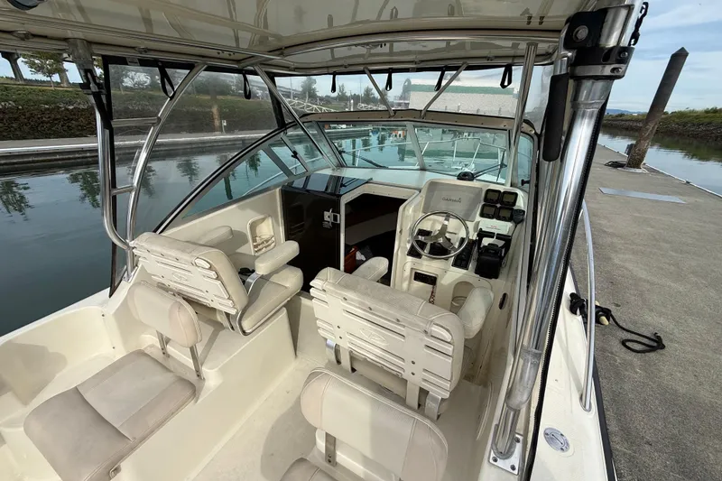 Slide: The Image of 2006 Pursuit 2570 Offshore boat interior with helm, seats, and dockside view. - 5