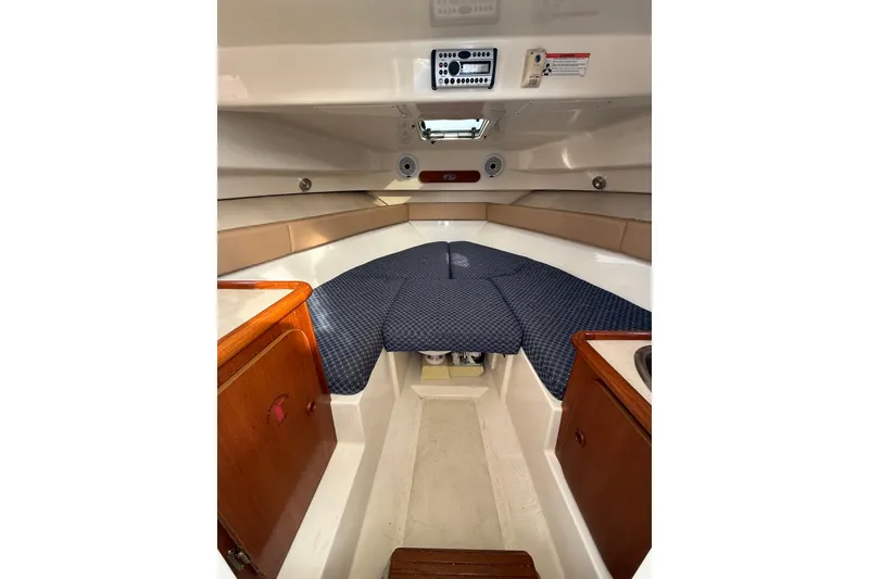 Slide: The Image of Interior cabin of 2006 Pursuit 2570 Offshore boat with cushioned seating and wooden cabinetry. - 14