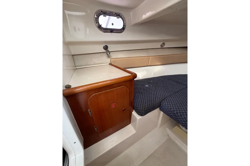 Slide: The Image of Interior cabin of 2006 Pursuit 2570 Offshore boat with wooden cabinet and cushioned seating. - 15