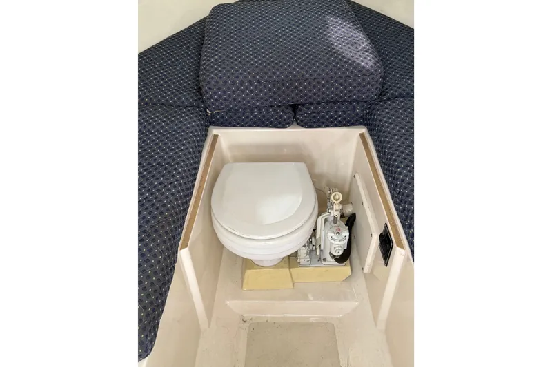 Slide: The Image of 2006 Pursuit 2570 Offshore boat interior with marine toilet and cushioned seating. - 18